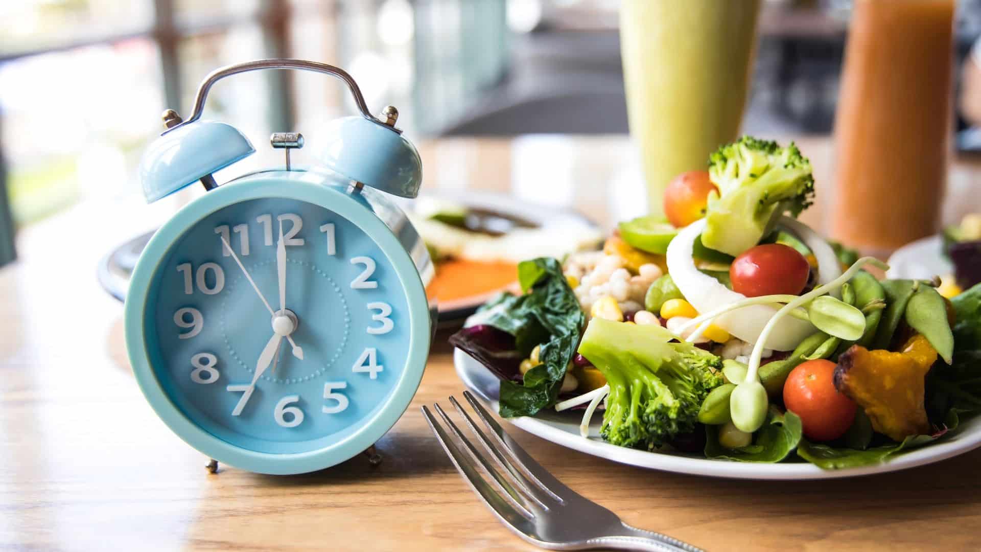 Teller mit Salat und eine Uhr daneben.